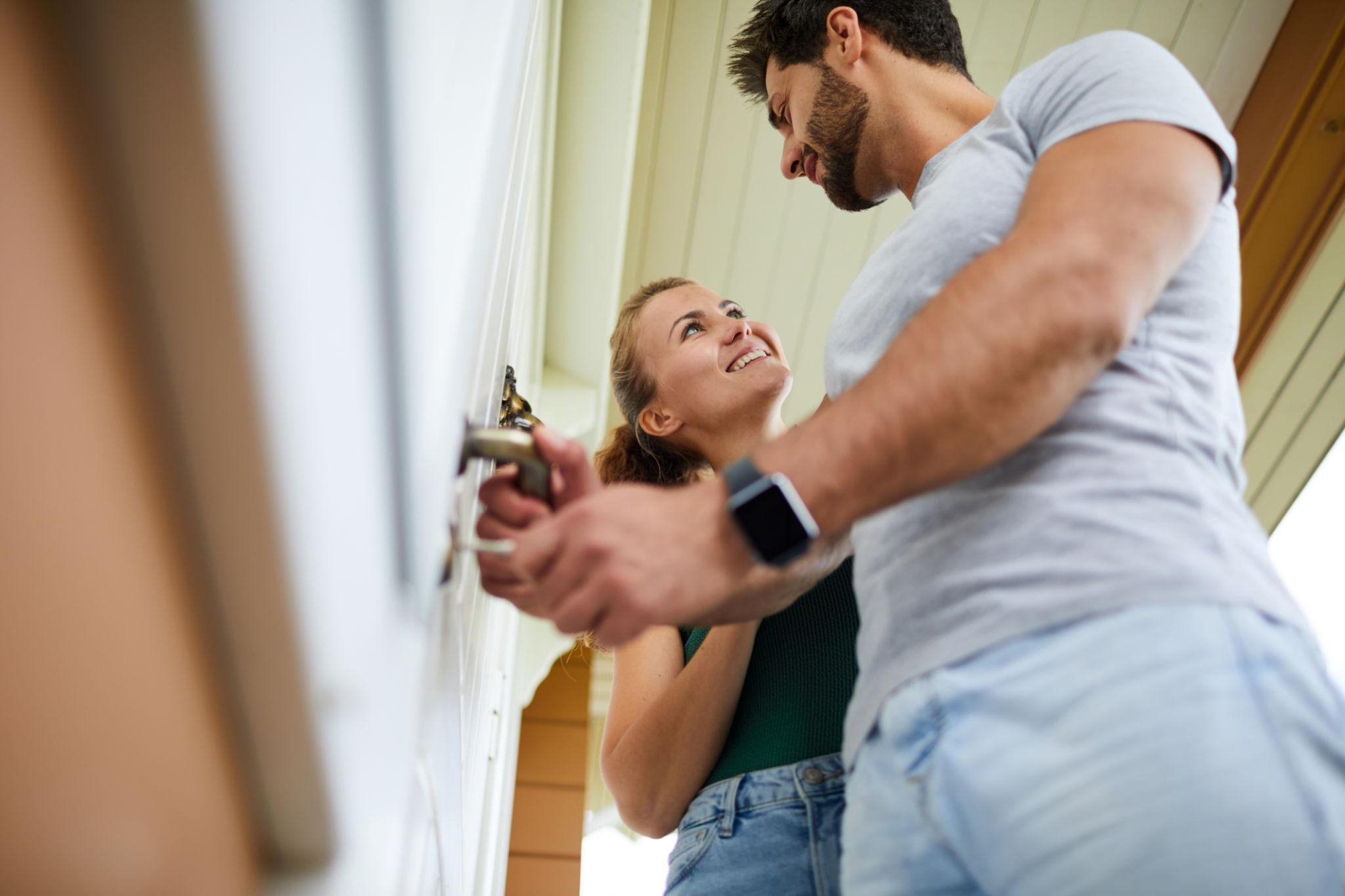 A happy couple unlocking the front door of their new home